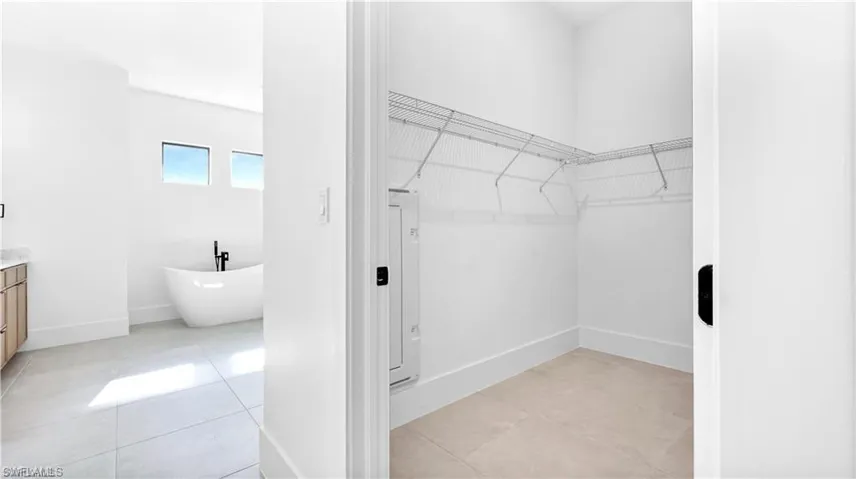 Walk in closet with light tile patterned flooring