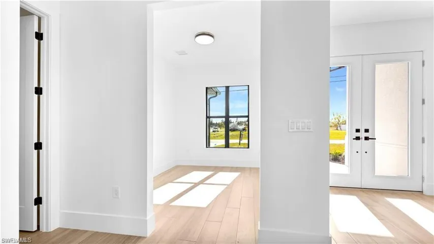 Foyer featuring french doors, light hardwood / wood-style flooring, and plenty of natural light
