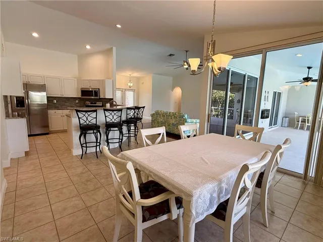 Dining space with recessed lighting, a chandelier, lofted ceiling, a ceiling fan, and light tile patterned floors