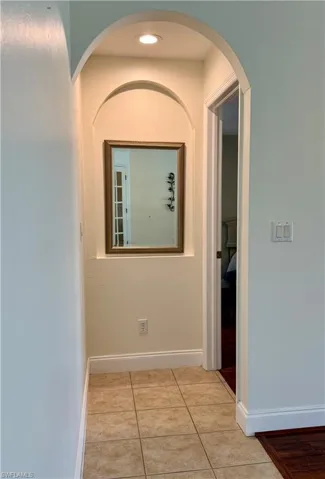 Hallway with tile patterned floors and arched walkways
