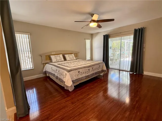 Bedroom featuring dark wood finished floors, access to outside, and a ceiling fan