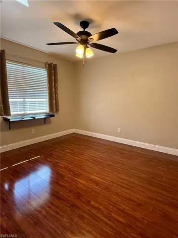 Spare room #2 with dark wood-style flooring and a ceiling fan