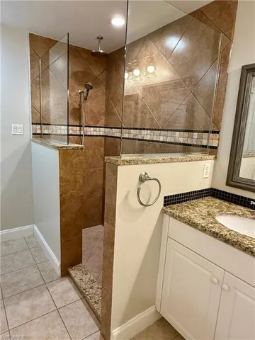 Bathroom featuring vanity, walk in shower, and light tile patterned floors