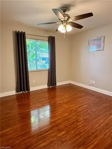 Spare room #1 featuring dark wood finished floors and ceiling fan