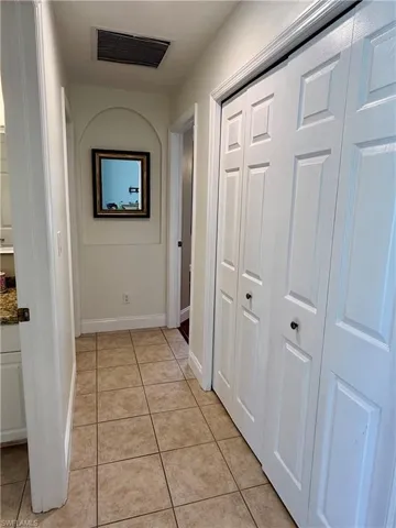 Hall featuring light tile patterned floors and closet for extra storage