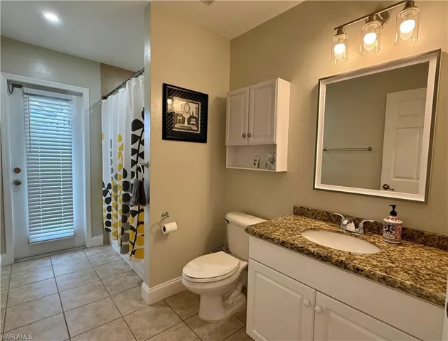 Bathroom with vanity, light tile patterned floors, with bath and shower combo
