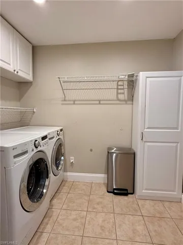 Washroom with light tile washer and dryer, and cabinet space