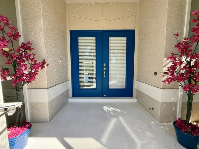 Property entrance featuring french doors is screened in