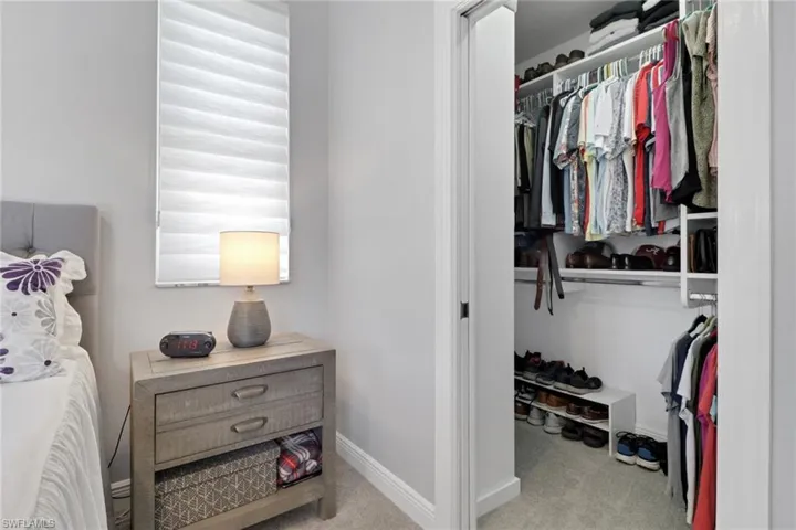 Walk in closet with light colored carpet, newly designed to hold at maximum capacity