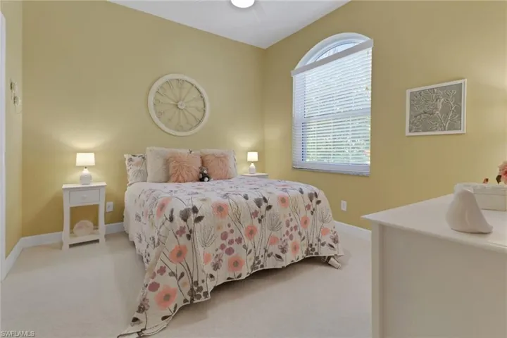Bedroom #2 featuring light colored carpet, plenty of natural light and high ceilings