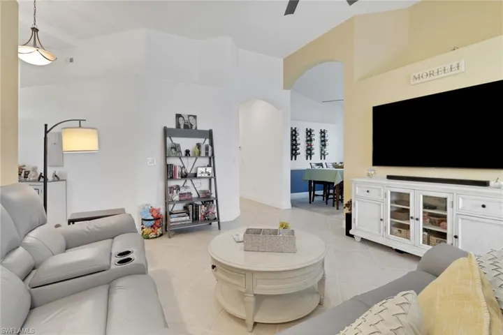 Living room with arched doorway (notice the heights for both doorways and ceiling) facing toward the dining room