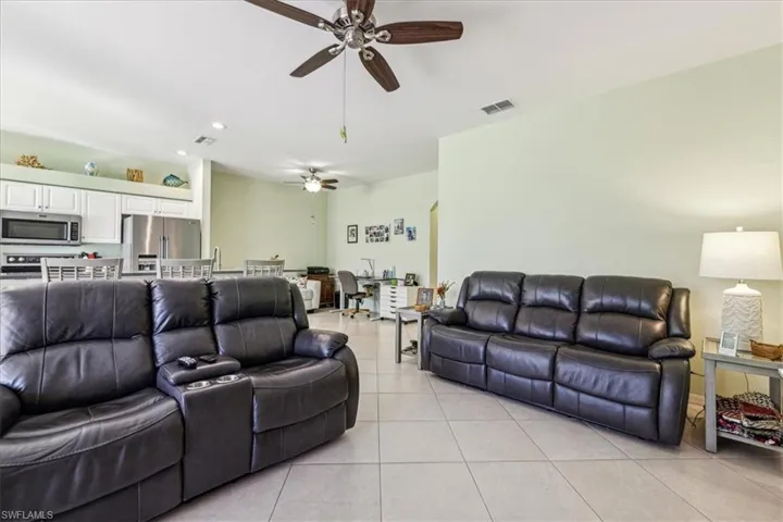 Living room with ceiling fan and light tile patterned floors