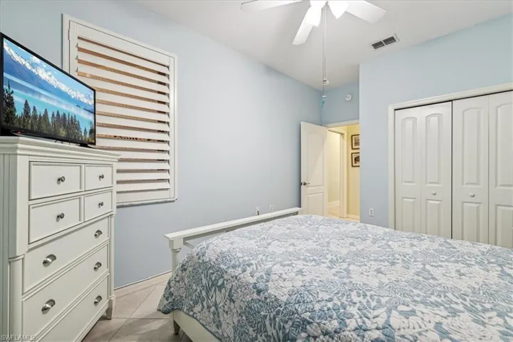 Tiled bedroom with a closet and ceiling fan
