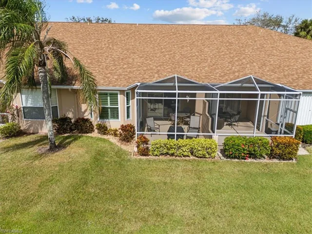Back of property with a patio, a lawn, and glass enclosure