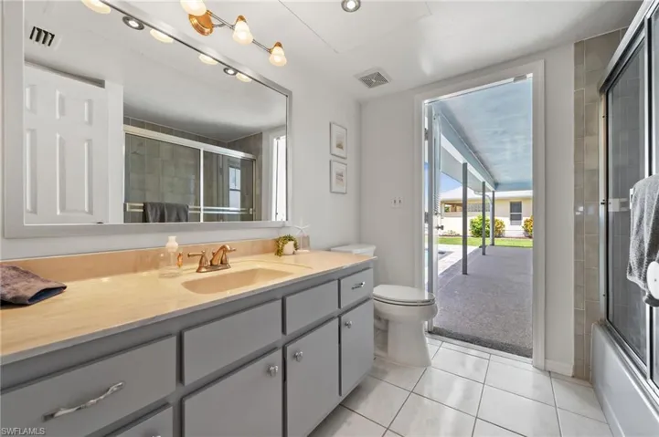 Main Bathroom with tub and access to the pool.