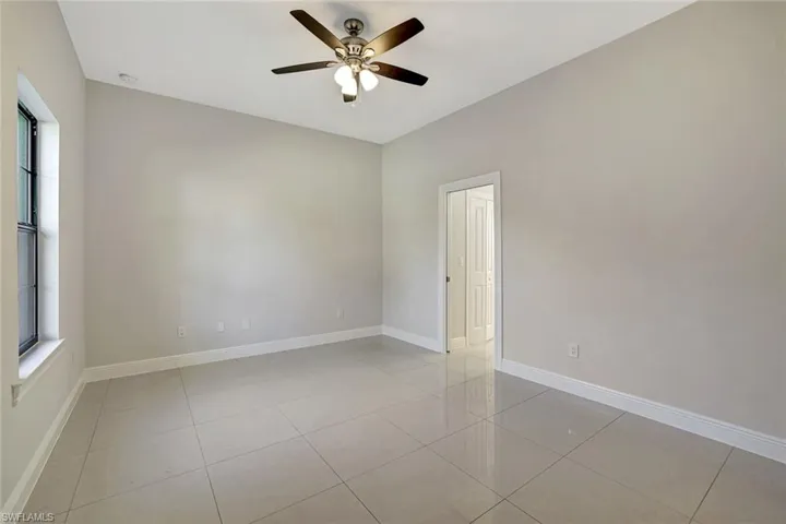 Unfurnished room featuring a ceiling fan and light tile patterned floors