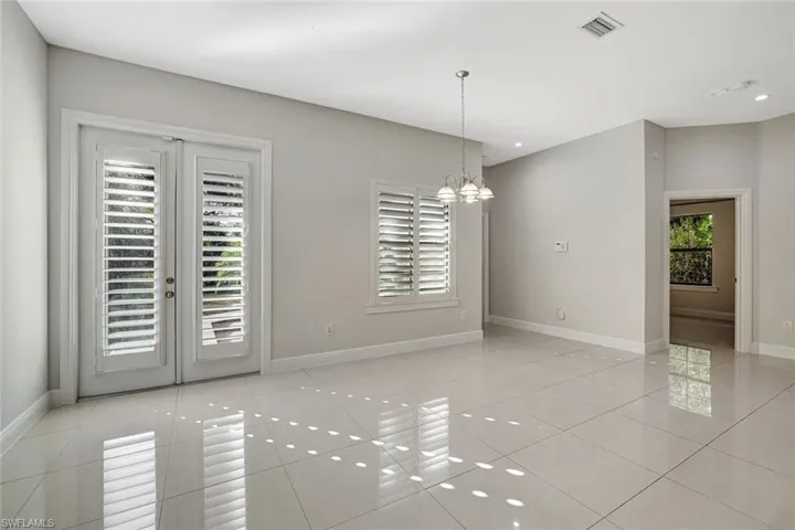 Unfurnished room with a chandelier, light tile patterned floors, recessed lighting, and french doors