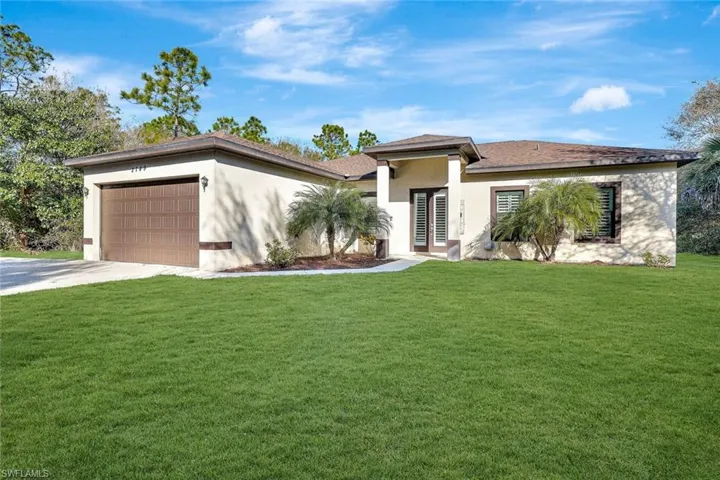 Prairie-style house featuring a front lawn, stucco siding, concrete driveway, and an attached garage