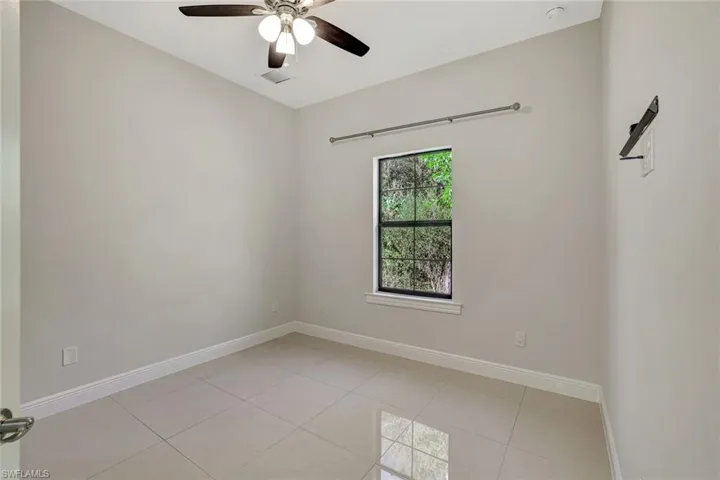 Spare room featuring light tile patterned floors and ceiling fan