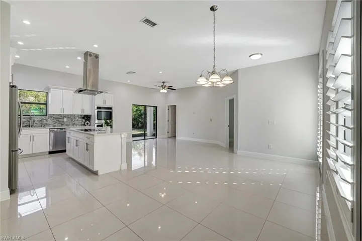 Kitchen featuring open floor plan, a kitchen island, plenty of natural light, island range hood, and recessed lighting