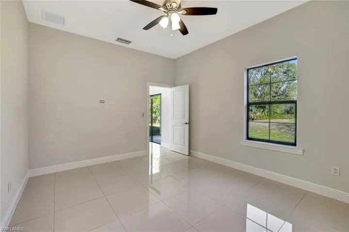 Spare room with light tile patterned flooring and a ceiling fan