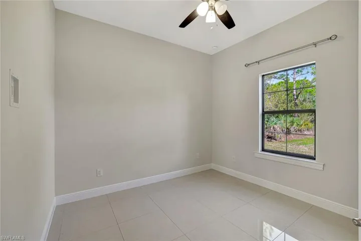 Unfurnished room with light tile patterned floors and a ceiling fan