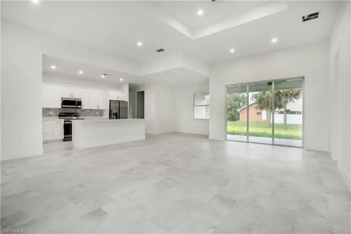 Unfurnished living room featuring a raised ceiling