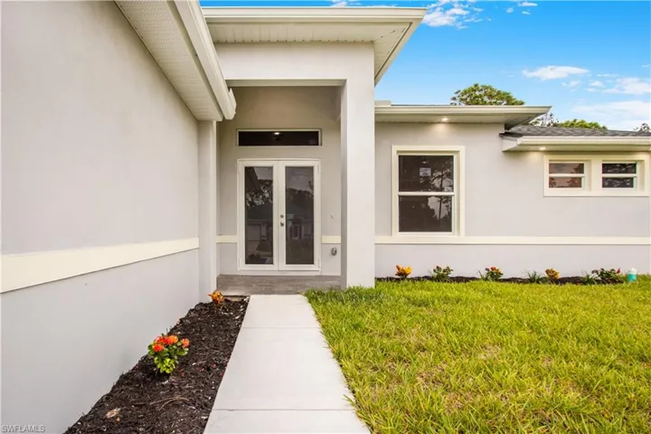 Property entrance with a lawn and french doors