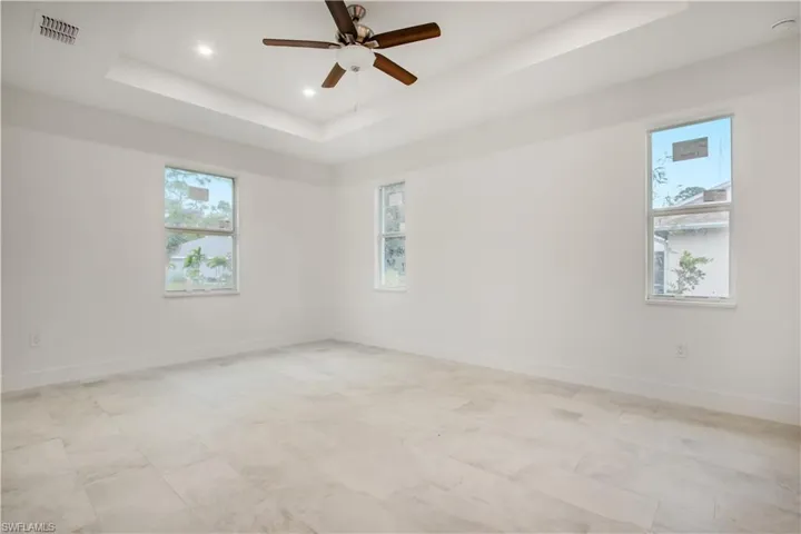 Spare room with a tray ceiling and ceiling fan