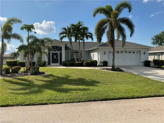 Single story home with a garage and a front yard