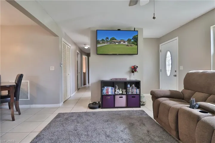 Tile flooring, neutral wall paint, white interior doors, and a decorative front door with an oval glass insert