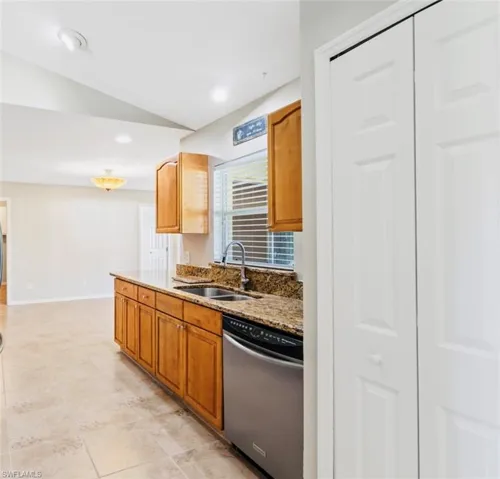 Kitchen featuring granite countertops, stainless steel appliances, recessed lighting, oak cabinetry, and neutral tile patterned flooring