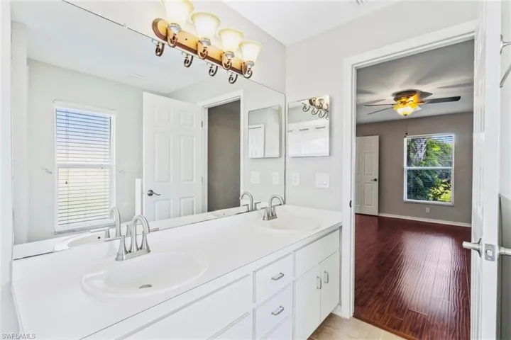 Primary full bathroom featuring double vanity and neutral tile patterned flooring