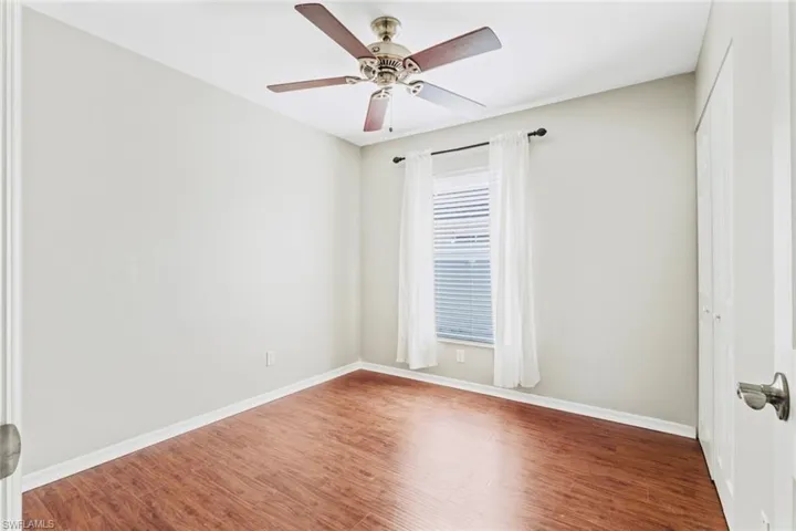 Guest Bedroom 1- featuring wood floors, ceiling fan and closet