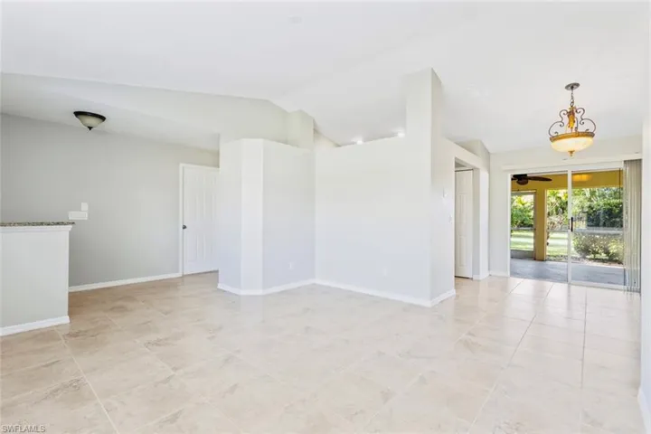 Living Room with lofted ceiling, baseboards and neutral tile patterned flooring