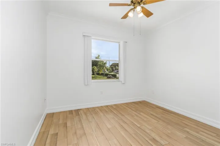 Unfurnished bedroom with light wood-style tile flooring, crown molding, and ceiling fan