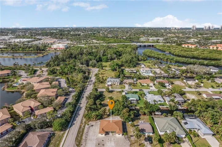 Aerial view of property and surrounding area featuring a nearby body of water and nearby suburban area