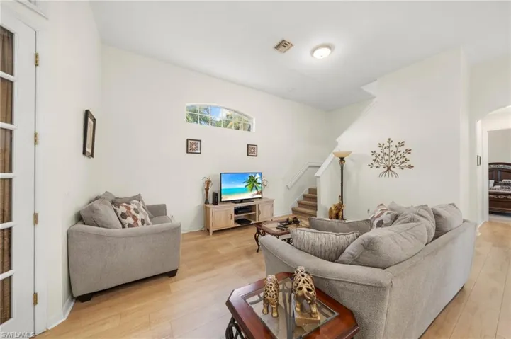 Living room with light wood-type flooring and arched walkways