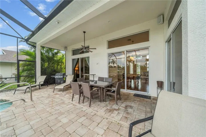 View of patio / terrace with a sunroom, outdoor dining area, ceiling fan, glass enclosure, and an outdoor pool