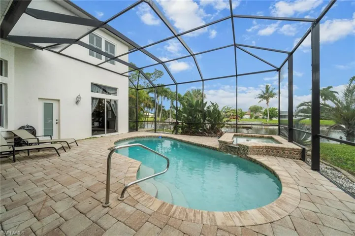 Integrated pool / hot tub featuring a sunroom, a patio area, and glass enclosure