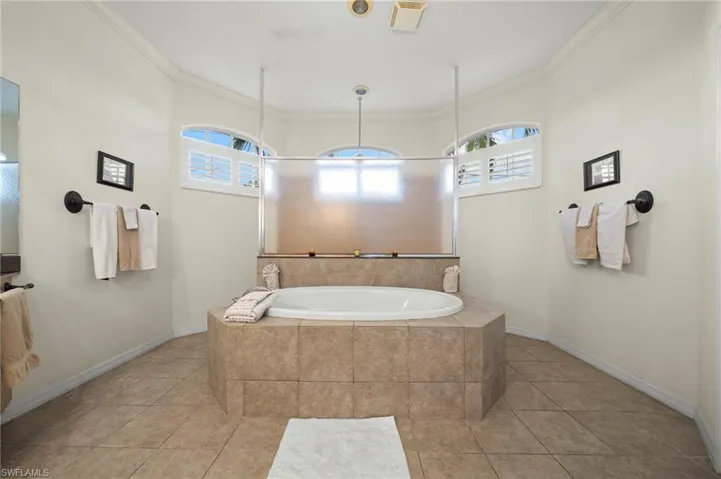 Bathroom featuring ornamental molding, a walk in shower, a bath, and light tile patterned floors