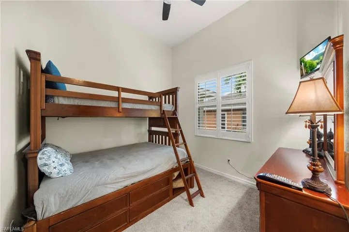Bedroom with light carpet and a ceiling fan