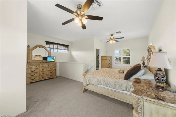 Bedroom featuring a ceiling fan and light colored carpet