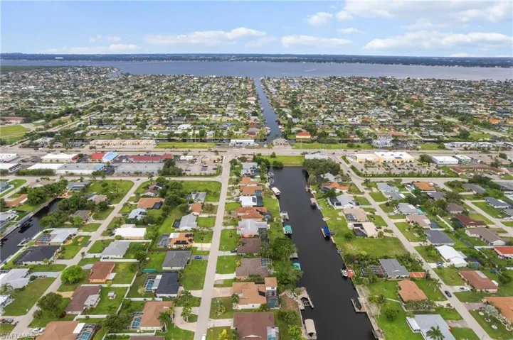 Aerial view of property's location with a large body of water and nearby suburban area