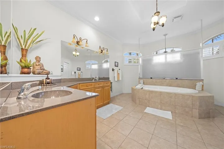 Bathroom with vanity, a bath, light tile patterned floors, ornamental molding, and recessed lighting