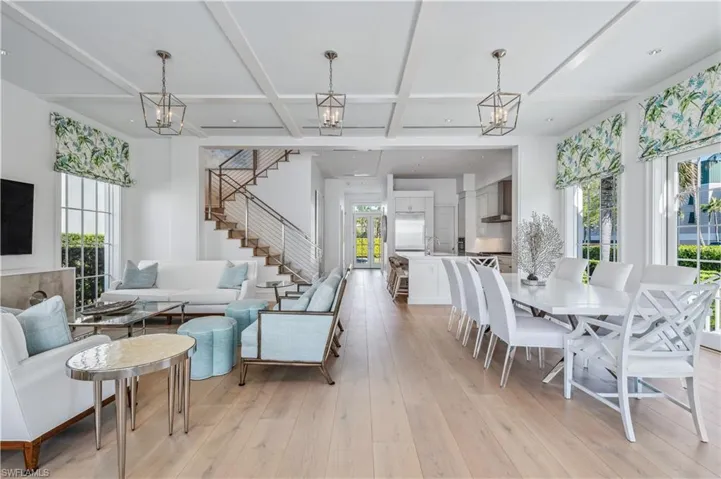 Living room featuring beamed ceiling, light wood-type flooring, a wealth of natural light, and coffered ceiling