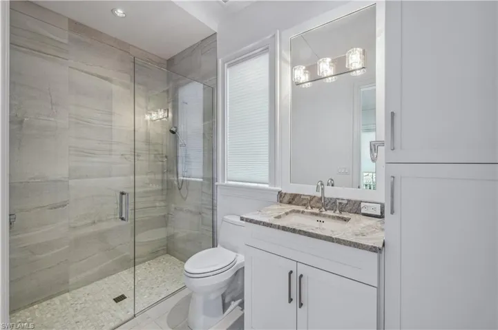 Bathroom with walk in shower, vanity, and toilet