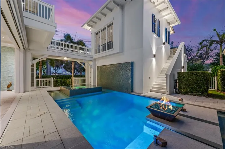 Pool at dusk with a patio and an outdoor fire pit