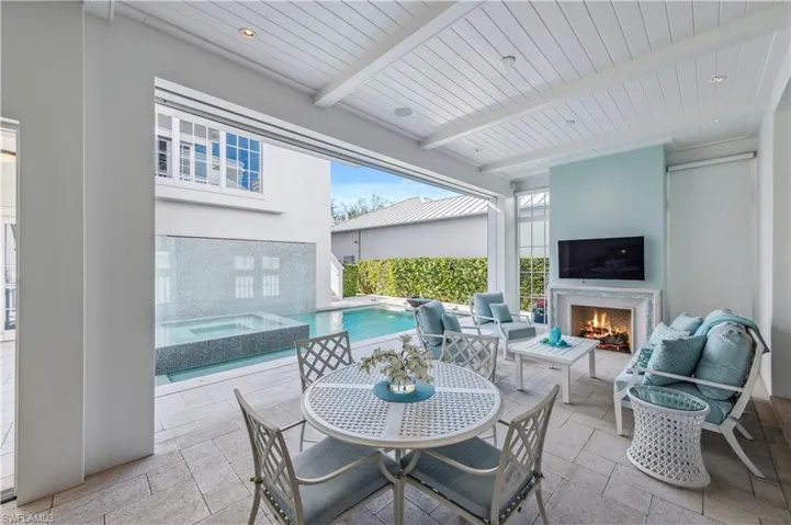 View of patio with an outdoor living space with a fireplace and a swimming pool with hot tub