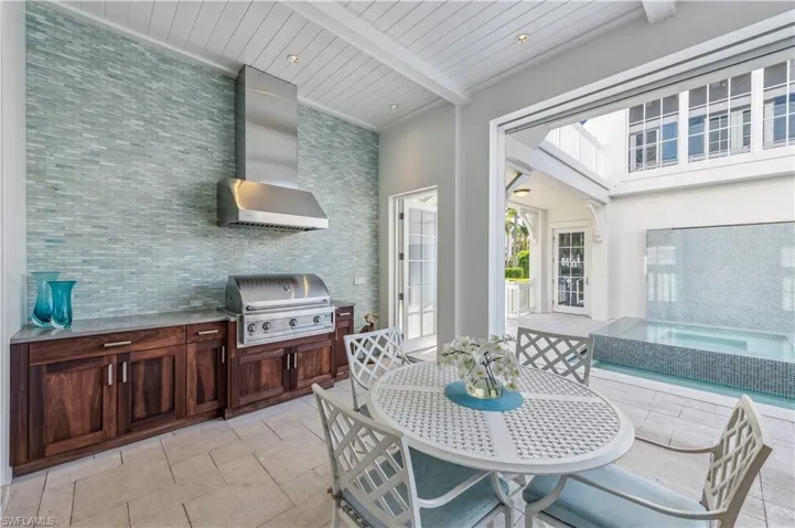 View of patio featuring an outdoor kitchen and a grill
